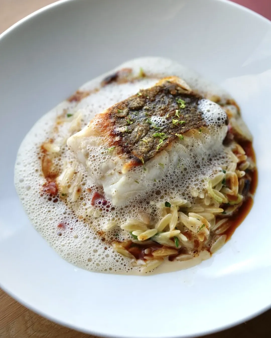 Seared fish, creamy risoni, foam and lime zest